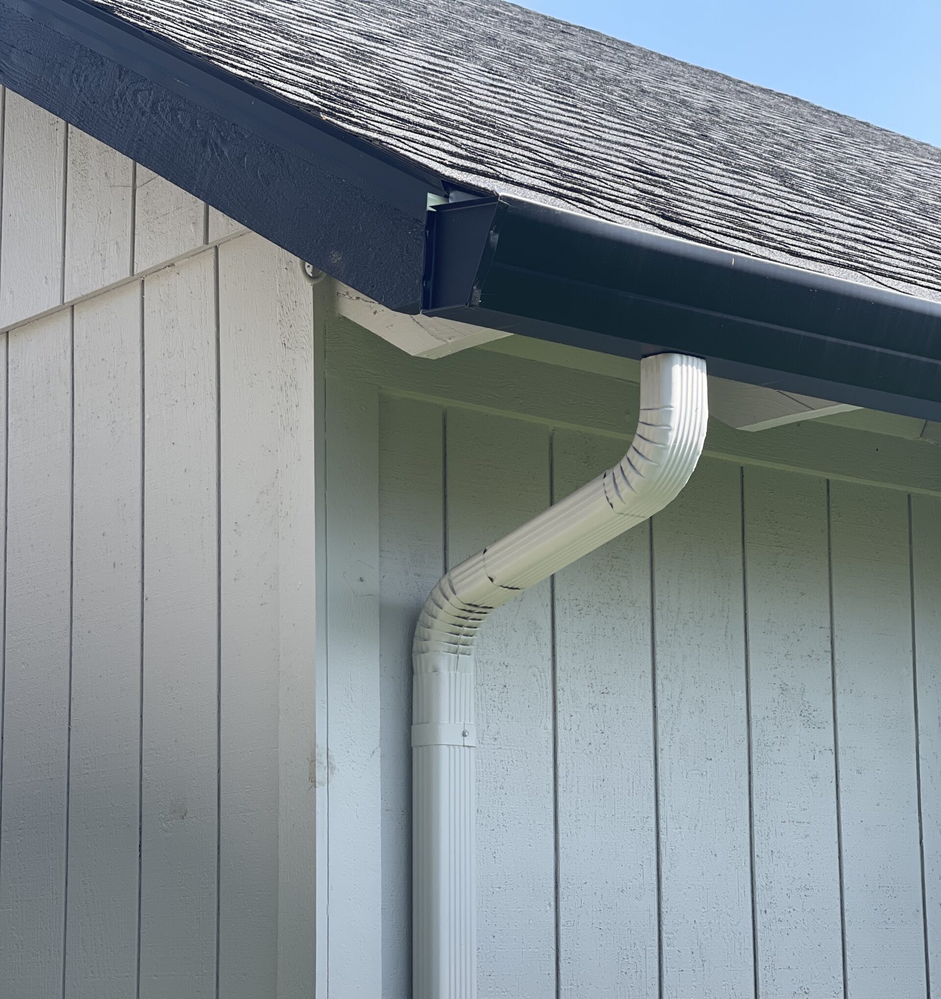 JT Wide Fascia gutter in black to match the trim, with 3x4 corrugated downspouts in gray to match the siding